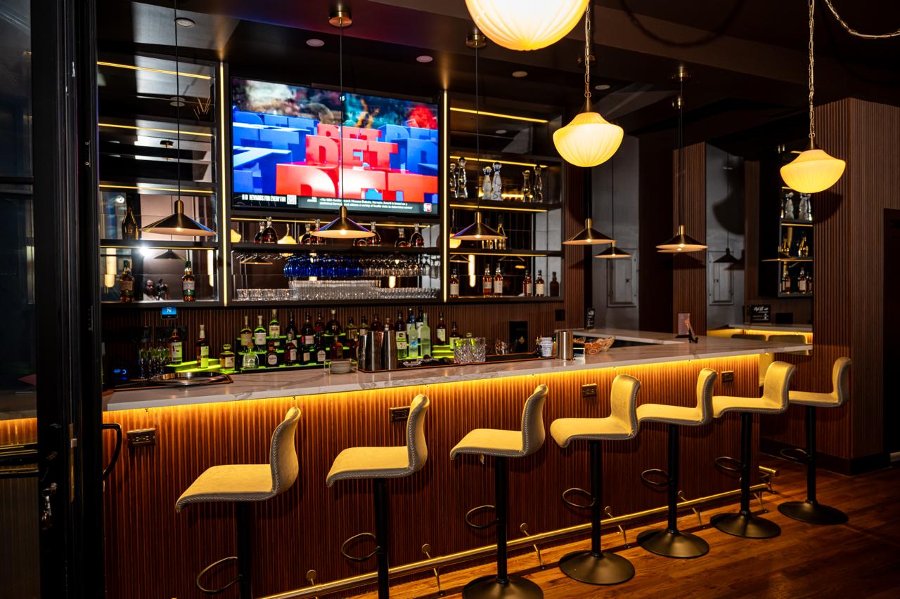 AURA dining room with brass lighting and polished seating